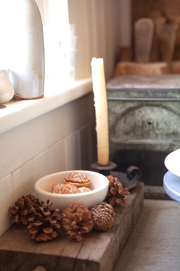 Pinecones on breadboard with candle.