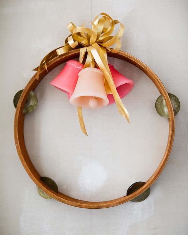 Vintage tambourine repurposed as a holiday wreath with bells.