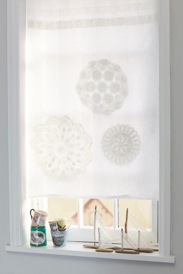 Linen curtain panel with hand-stitched doilies. 