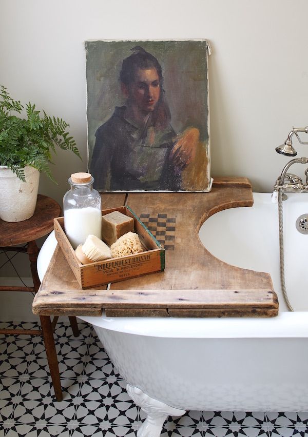 Old wood checkerboard serves as a tray on the tub in the bathroom.